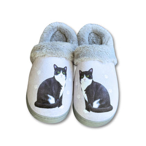 a pair of slippers with a black and white cat on them